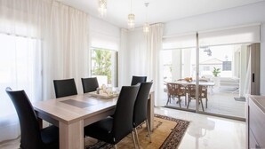 Un espace repas moderne avec une table en bois, des chaises noires et un plateau décoratif.