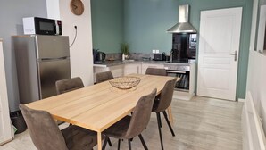 Una cocina moderna con comedor, electrodomésticos de acero inoxidable y una mesa de madera.