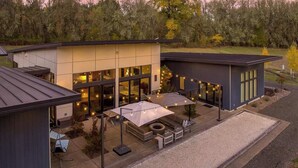 Een modern huis met een patio, buitentafels en sfeerverlichting.