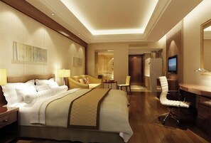 Une chambre d’hôtel avec un grand lit, un bureau, une chaise, une télévision et une petite table.