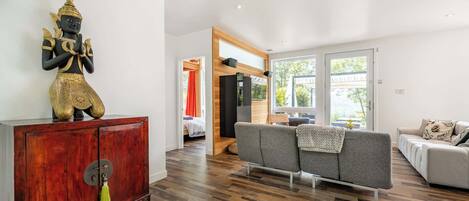 Un salon moderne avec un meuble en bois, un canapé et une statue.