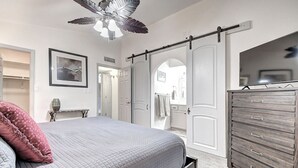 A bedroom with a bed, a dresser, a ceiling fan, and a sliding door closet. - Mesa Lake Front House With Pool and Hot Tub! (Mesa)