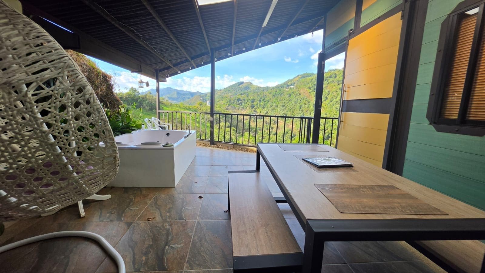 Un área de estar al aire libre cubierta con vistas a un paisaje montañoso.