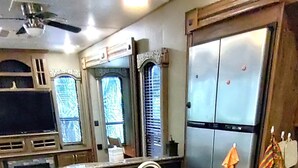 A kitchen with a central island, a built-in sink, and a refrigerator.