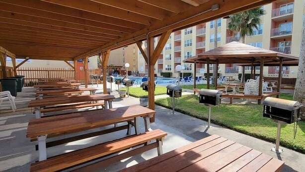 A covered outdoor area with wooden benches and mailboxes.