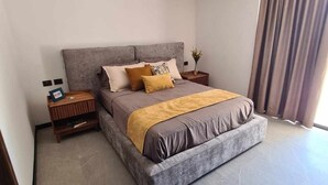 Ein modernes Schlafzimmer mit einem großen Bett, einem Nachttisch und einer Nachttischlampe.