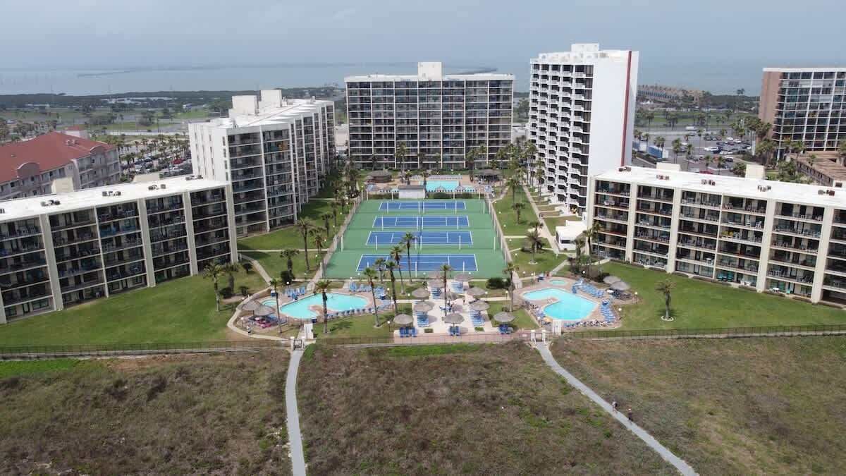 Un hôtel de grande hauteur, avec de nombreux étages, une cour intérieure dotée de terrains de tennis et un espace piscine.