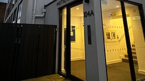 A modern building with a sign reading "WEST ELM STUDIO 104A".
