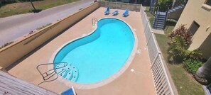 A swimming pool with a curved edge, a diving board, and lounge chairs. - * Pool  * 2 Levels * 2 Patios * Near Beach (South Padre Island)