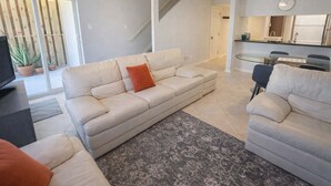 A living room with a sofa, a coffee table, a TV, and a dining area with a table and chairs. - * Pool  * 2 Levels * 2 Patios * Near Beach (South Padre Island)