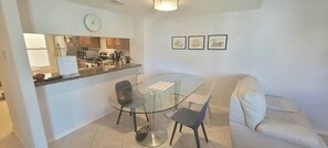 A compact living space with a kitchenette, a glass dining table, and a sofa. - * Pool  * 2 Levels * 2 Patios * Near Beach (South Padre Island)