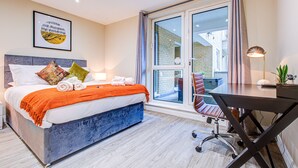Une chambre d’hôtel moderne, dotée d’un grand lit, d’un bureau et offrant une vue sur l’extérieur.
