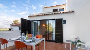 An outdoor dining area with a table set for two, chairs, and a bowl of fruit. - Holiday Home 'Cool Motion 2149' with Private Terrace, Wi-Fi and Air Conditioning (Albufeira)