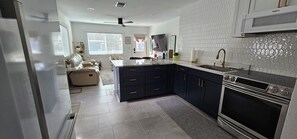 Een moderne keuken met donkere kasten, een inbouwoven en een magnetron.