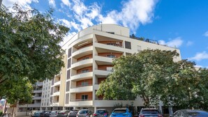 A multi-story building with a parking lot in front. - Apartment 'Cool Motion Rocha Beach T1' with Balcony, Wi-Fi and Air Conditioning (Portimão)
