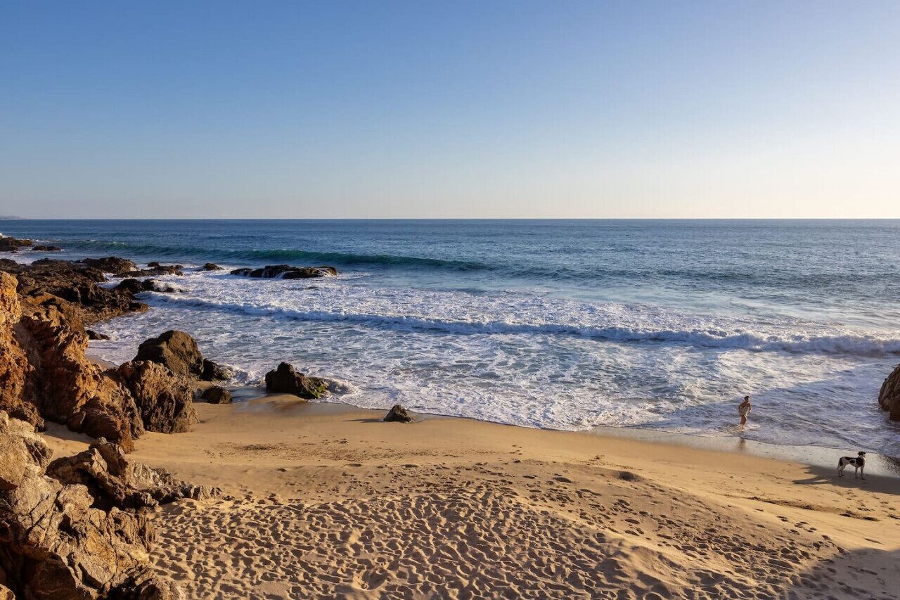 A beach with rocky formations and waves.