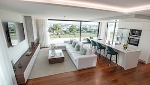 Un salon moderne comprenant un canapé, une table basse et un coin repas avec des chaises.