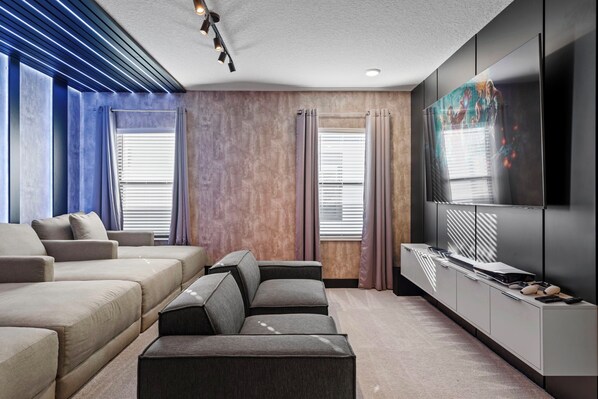 A modern living room with a sectional sofa, a flat-screen TV, and a minimalist design.