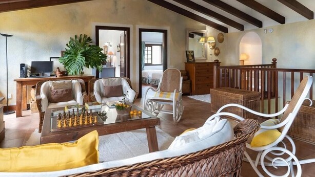 A spacious living area with a chessboard, wicker furniture, and a balcony with a railing. - Beautiful garden, spectacular view and privacy, ideal for nature lovers. (Tegueste)