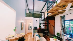 Ein modernes Interieur mit Essbereich, Sofa, Treppe und Bücherregalen.