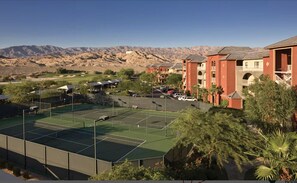 Play a game of tennis amidst lush greenery and palm trees, with the surrounding mountains and golf course providing a scenic backdrop.