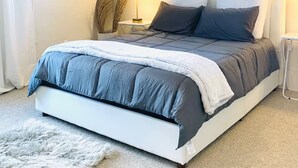 A bedroom with a bed, bedside lamps, a window, and a ceiling light fixture. - The Roundhouse Charming 4BR House w/ Jacuzzi Tub, WiFi and AC in Central Pueblo (Pueblo)