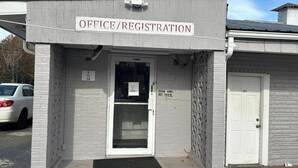 A building with a sign reading "OFFICE/REGISTRATION" above a door. There is a sign on the door that says "Please ring the bell for rooms." - Tri-City Motel by OYO Forrest City Spindale (Spindale)