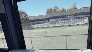 A bar area with a view of a sports field through a window.