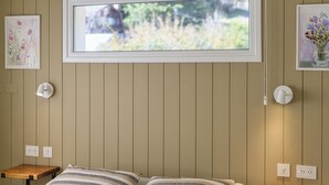 A bedroom with a bed, two bedside tables, a window, and wall-mounted light fixtures. -  Apartments Bariloche - San Martin de los Andes Cabins   (San Martín de los Andes)