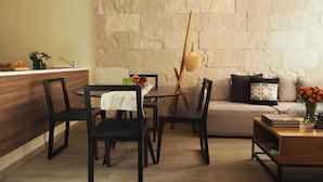 A modern living room with a stone wall, a wooden dining table with chairs, a sofa, and a coffee table. - Mirador Pushkin by The Local Way (Mexico City)