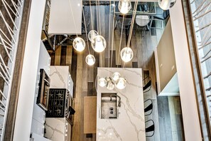 A modern kitchen with marble countertops, a built-in oven, and pendant lighting. - Exquisitely Designed Gem! Roof Deck+Patio (Philadelphia)