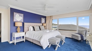 Relax in this inviting room with a large bed, comfortable chair, and stunning sea views.