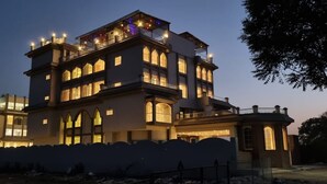 Un immeuble à plusieurs étages doté d’un balcon au dernier niveau, de grandes fenêtres et d’une entrée sécurisée par un portail.