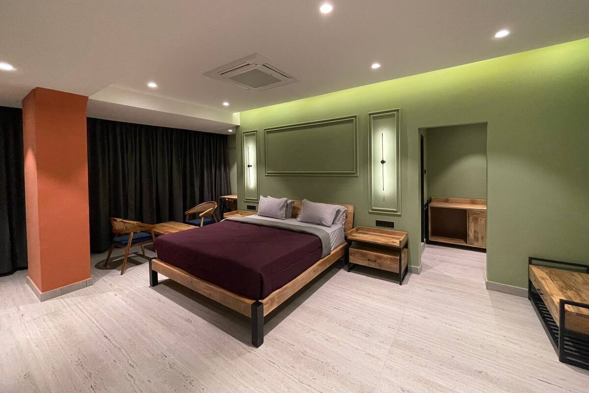 Une chambre moderne avec un grand lit, des tables de chevet, un bureau et une armoire.