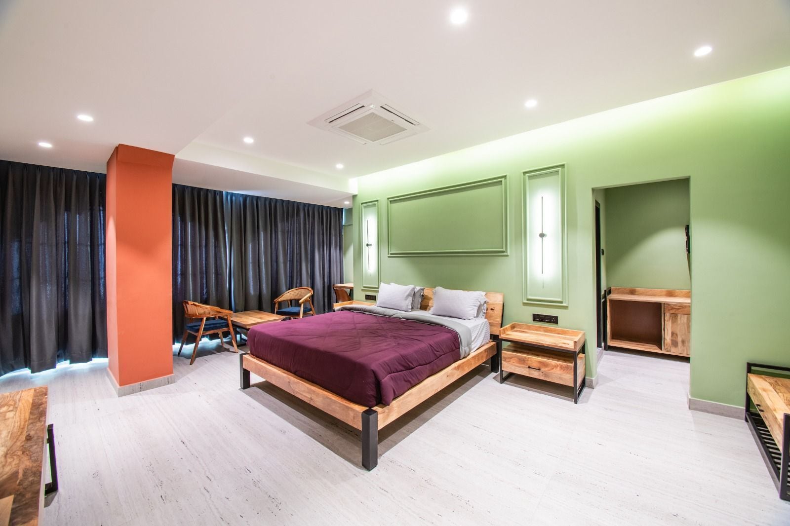 A modern bedroom with a large bed, a desk, and a chair.