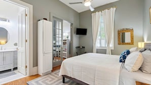 A bedroom with a bed, a ceiling fan, a TV, and a wardrobe. - The Retreat off Magazine (New Orleans)