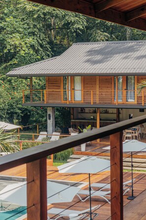 A two-story wooden house with a balcony, outdoor seating, and a pool. - S Boutique Hotel  (Bocas del Toro)