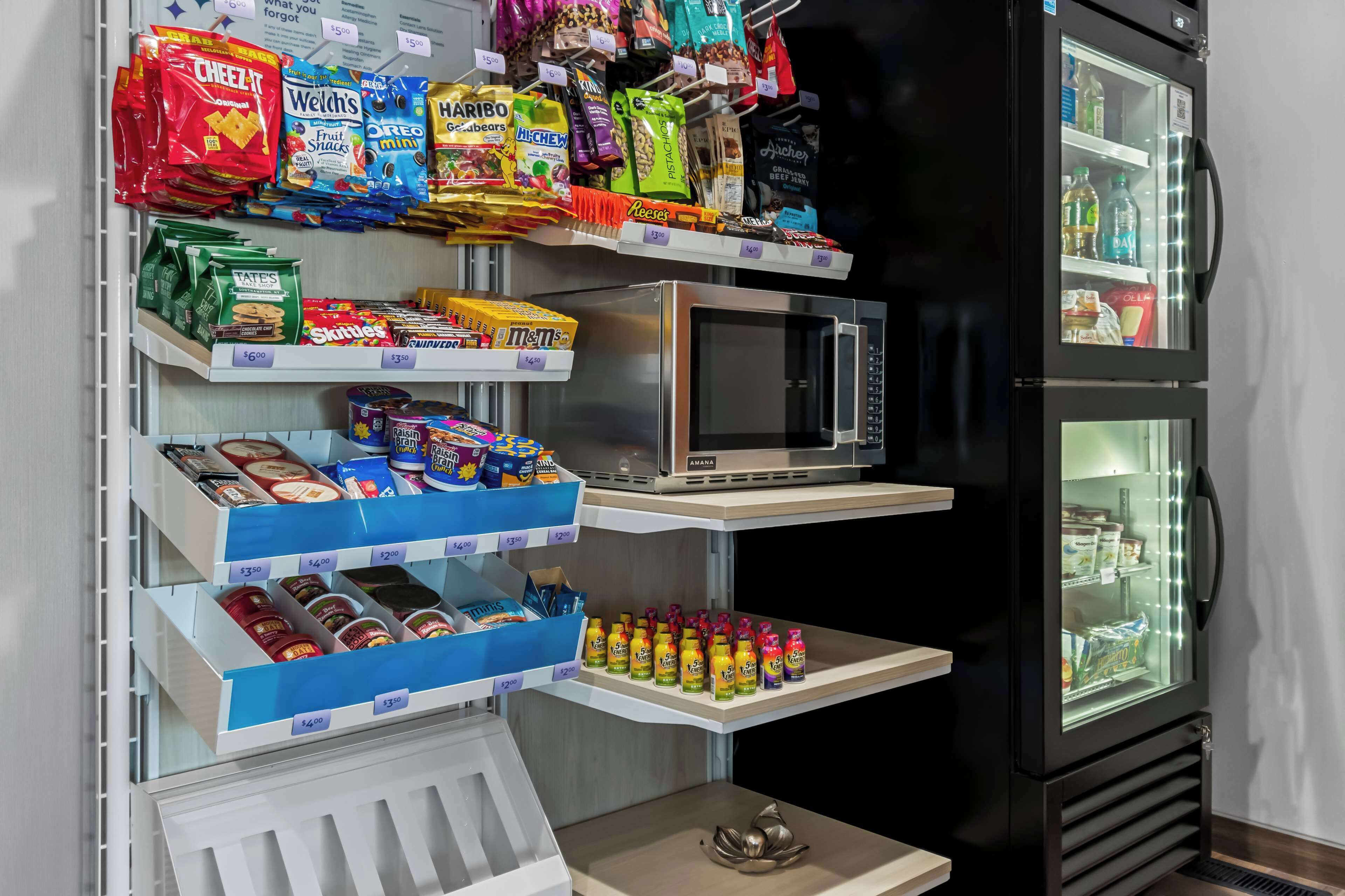 A snack display with various packaged foods and a microwave.