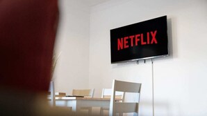 Ett rum med en platt-TV som är monterad på väggen och som visar Netflix-logotypen.