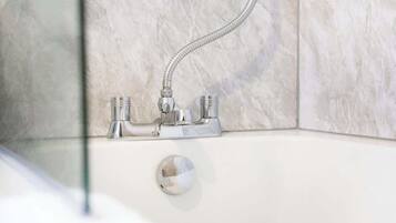 A bathroom with a shower, a bathtub, and a glass-enclosed shower area.