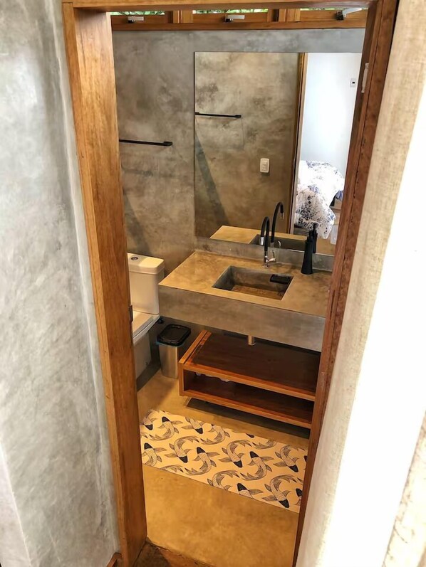 A narrow bathroom with a large mirror, a sink, and a toilet. - Verde Mar Ilha Grande (Angra dos Reis)