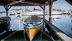 Un barco de madera amarrado en un puerto deportivo con un muelle techado.