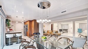 Une cuisine moderne avec un coin repas, des éléments décoratifs en bois et un îlot central.