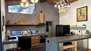 A modern kitchen with a central island, built-in appliances, and a large window providing natural light. - The Soul of the River  (Three Rivers)