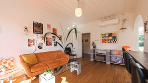 A living room with a sofa, coffee table, and various wall art.