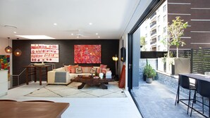 Un salon moderne avec un canapé, une table basse et des œuvres d’art accrochées au mur.