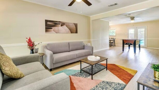 A living room with a gray sofa, a coffee table, and a pool table. - The Temple Retreat (Temple)