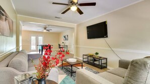 A living room with a sofa, coffee table, and a TV mounted on the wall. - The Temple Retreat (Temple)