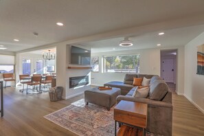 A spacious living room with a large sectional sofa, a dining area with a table and chairs, and a fireplace. - Spacious & Stocked: 2Kings+Hot Tub+Fire Pit+Family Fun (Albuquerque)