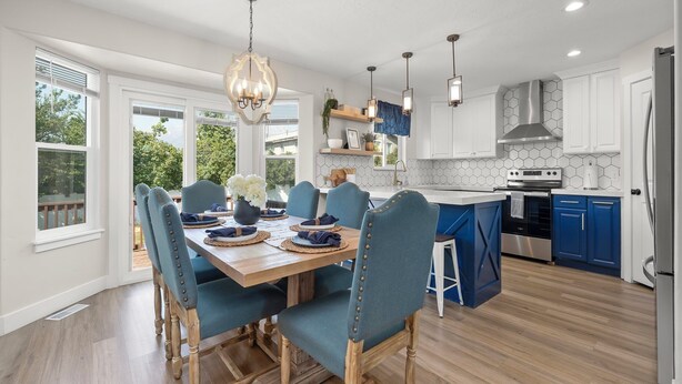 A modern kitchen with white cabinets, a central island, and blue accents.